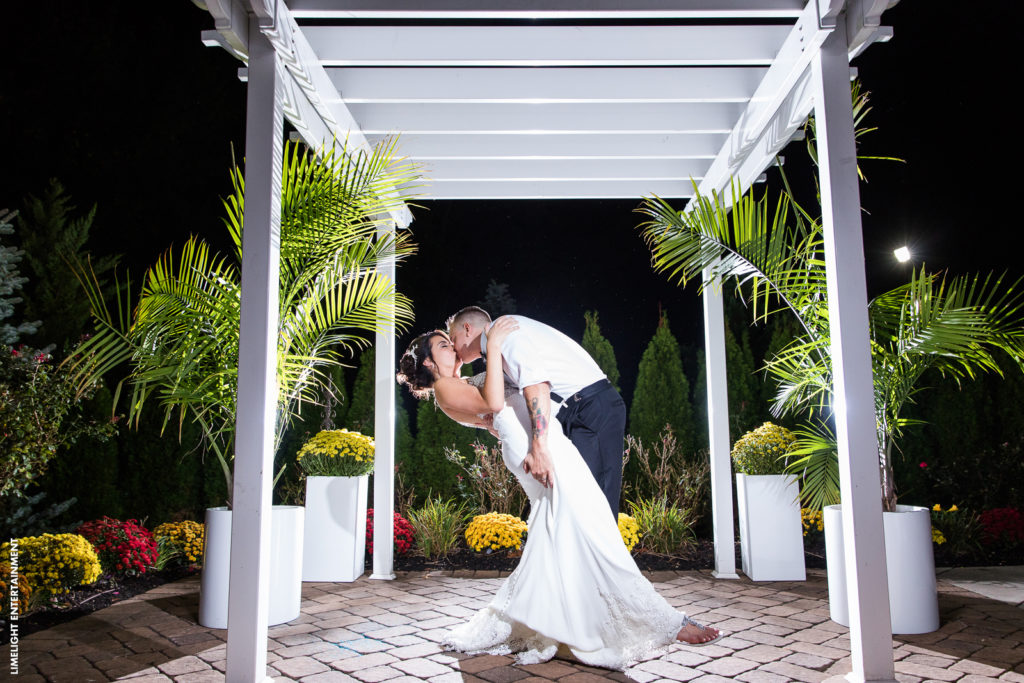 Bride and groom stealing a kiss under the pergola at the Sterling Ballroom.