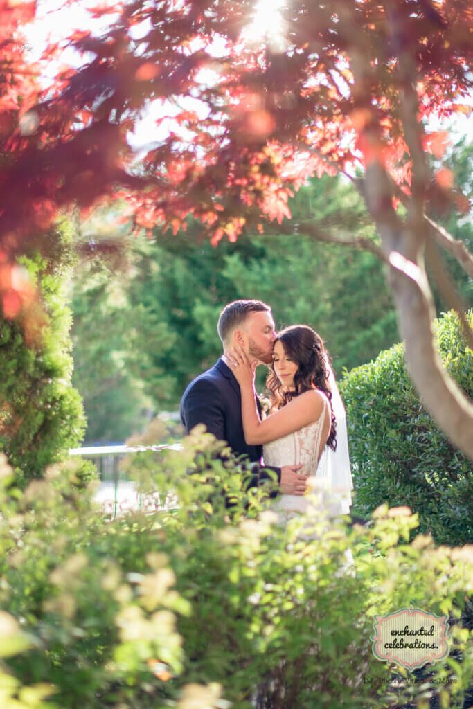 bride and groom posed in our courtyard with fall trees and leaves.